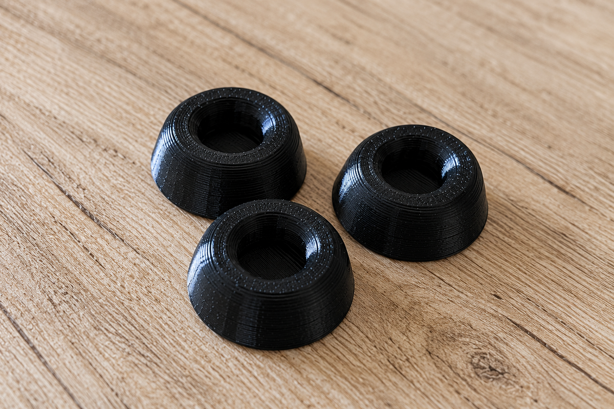 Three black SICLab replacement feet arranged on a wooden surface